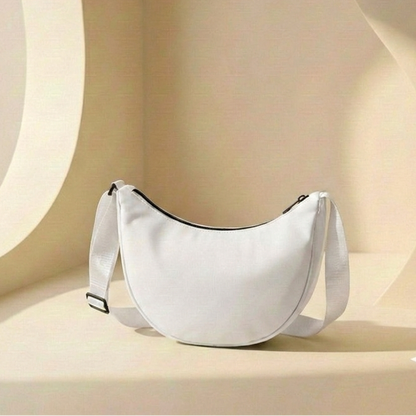 White crescent-shaped bag on a beige background