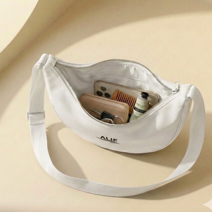 White crossbody bag with "alif" brand name on a beige background