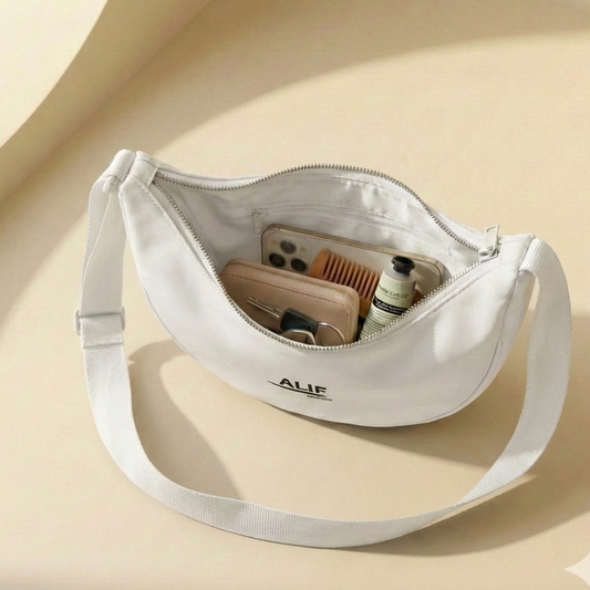 White crossbody bag with "alif" brand name on a beige background