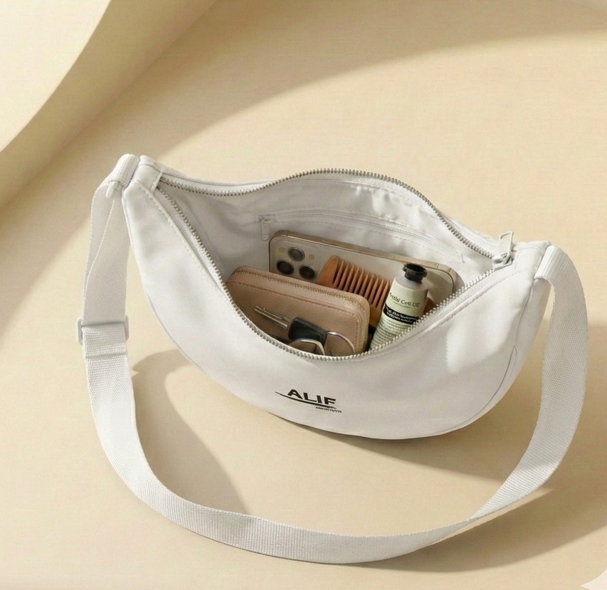 White crossbody bag with "alif" brand name on a beige background