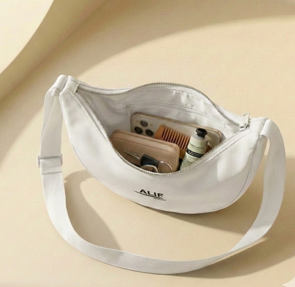 White crossbody bag with "alif" brand name on a beige background